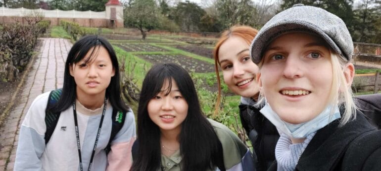 四名年輕人在戶外花園前近距離自拍