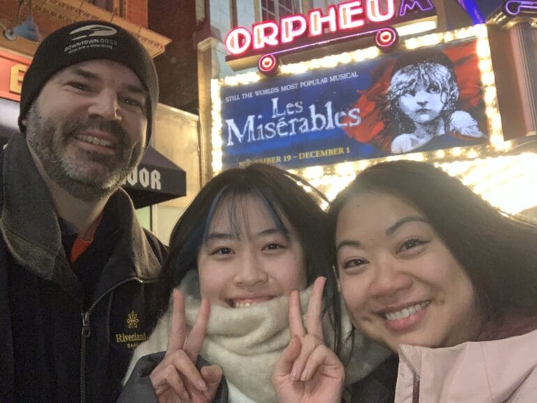 三人在劇院外與音樂劇招牌合照